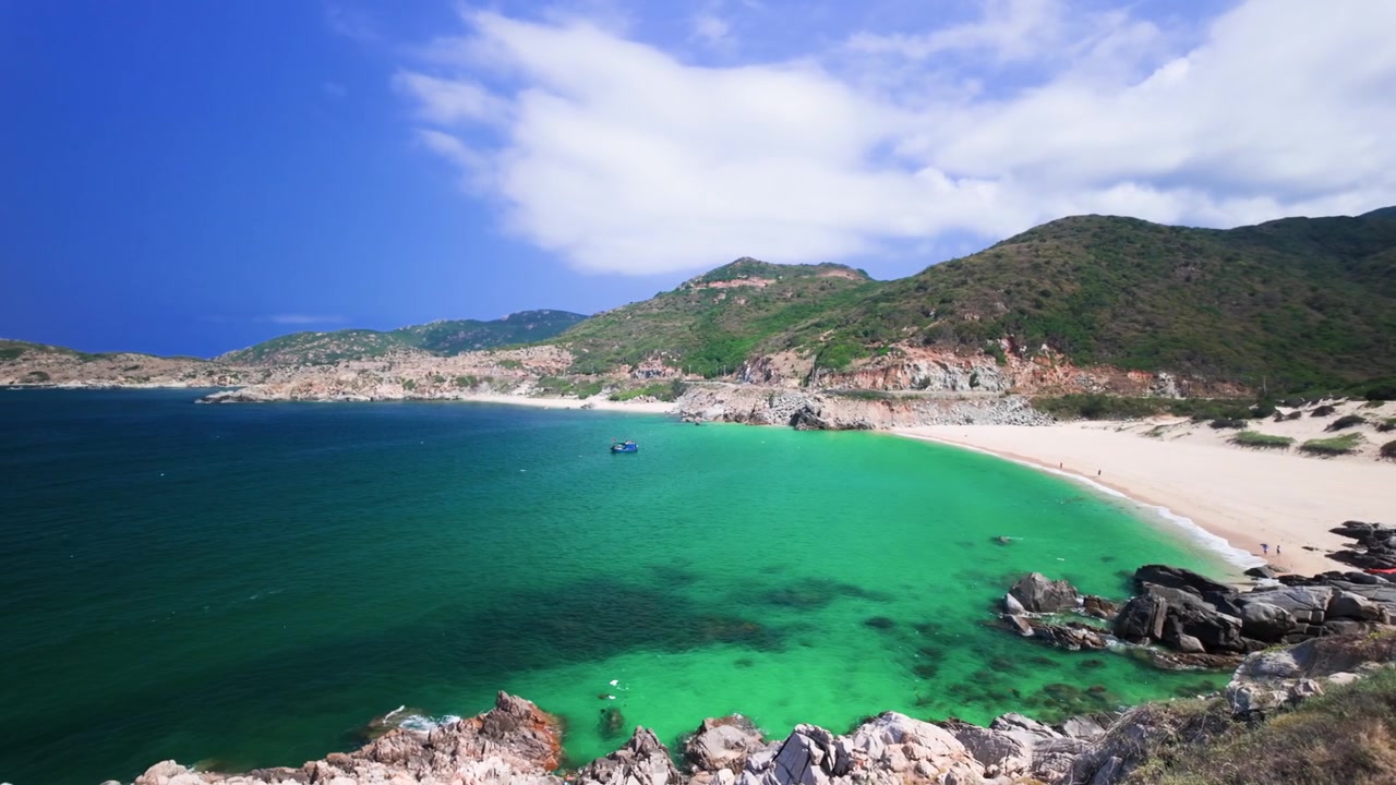 Descubre Dak Lak en Vietnam, donde aguas cristalinas se encuentran con playas de arena. Observa los barcos de pesca mientras navegan por la costa bajo un cielo brillante. Experimenta la belleza natural de esta zona.
