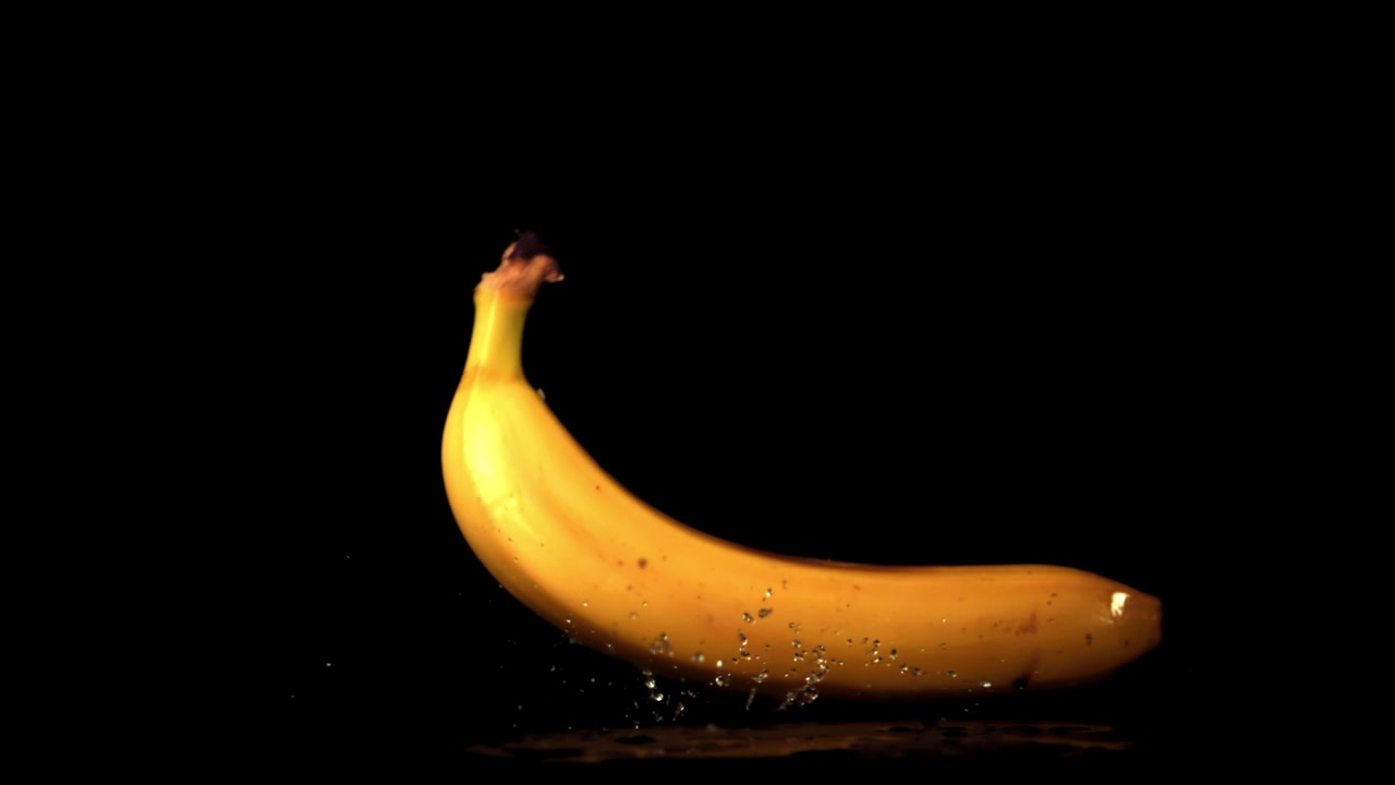 Banane jaune tombant et éclaboussant au ralenti