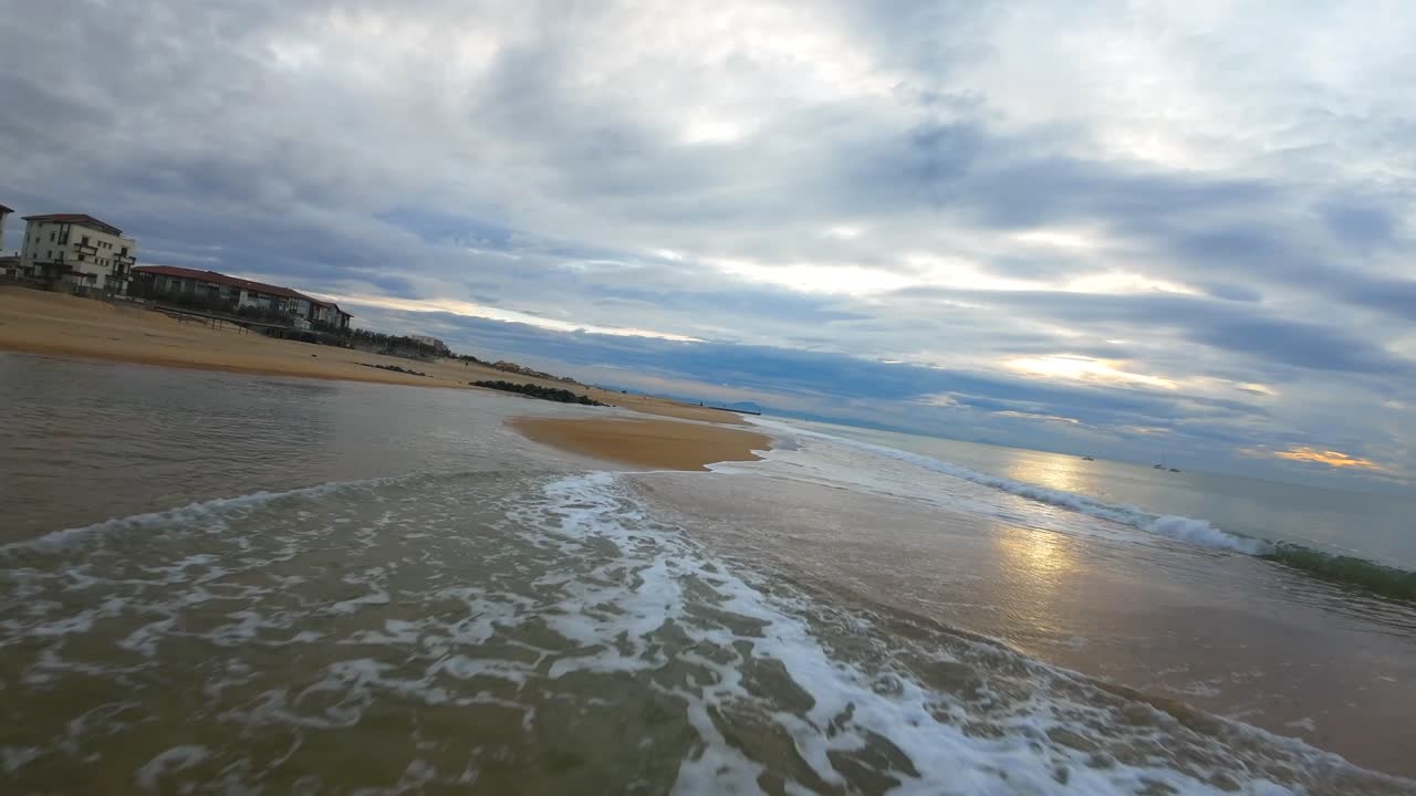 vuelo de drones fpv sobre las olas en la playa de surf de hossegor durante una puesta de sol nublada