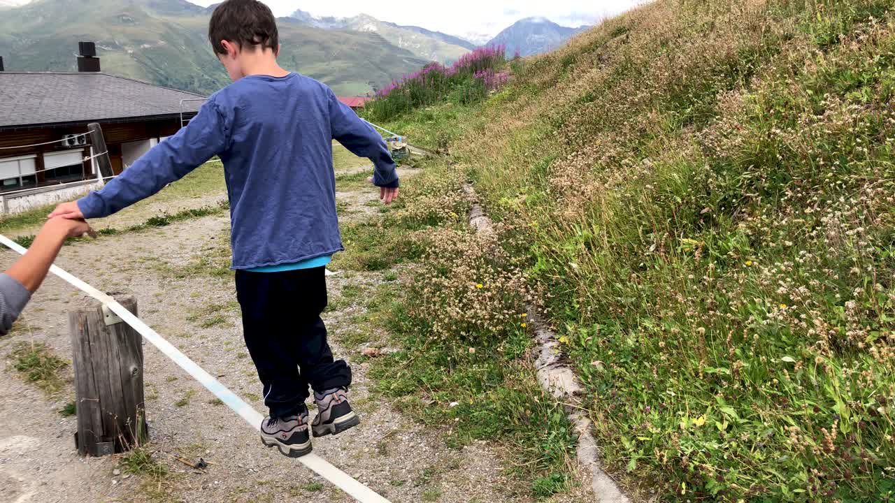 도움을 받아 슬래그라인을 시도하는 귀여운 어린 소년