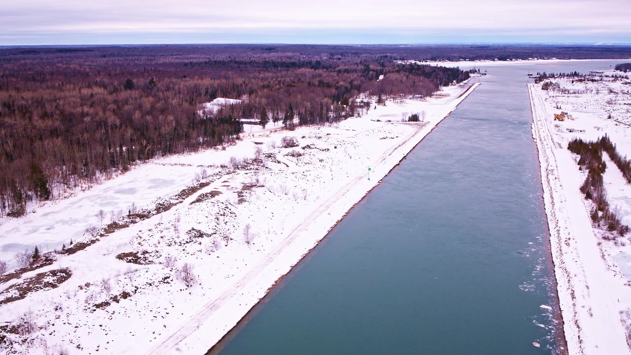 Dronekuva talvisesta erämaasta, joka johtaa osittain jäätyneelle lahdelle Yläjärven rannalla.