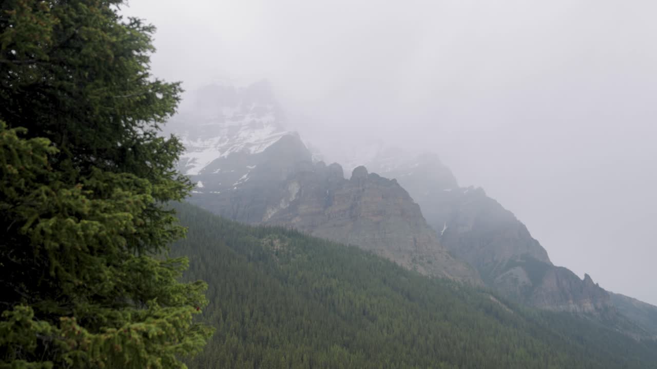 Vista della catena montuosa che circonda il Lago Moraine nel Parco Nazionale di Banff, Alberta, in un pomeriggio leggermente nebbioso