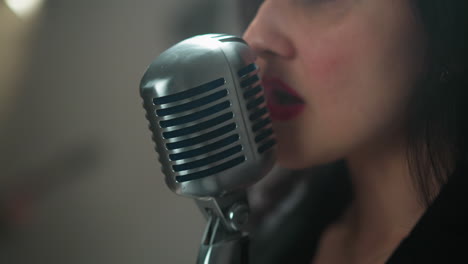 close-up of a female singer's lips and vintage microphone, singing against a blurred background