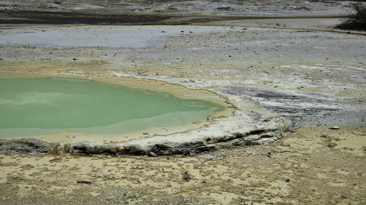 toma panorámica de la piscina de agua de color verde y el paisaje volcánico en el país de las maravillas geotérmicas de waiotapu, nz