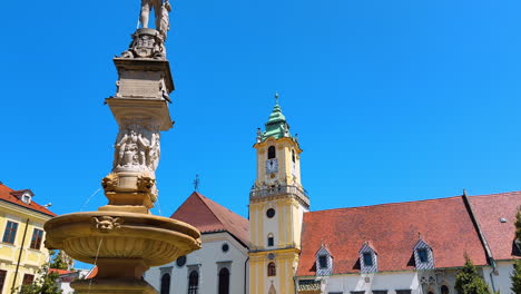 clock tower in the square of bratislava, slovakia. low angle view at the fountain in the old historical town