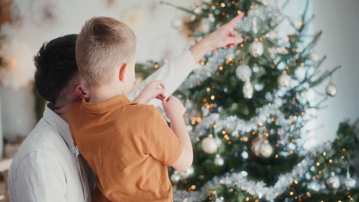 отец и сын украшают рождественскую елку