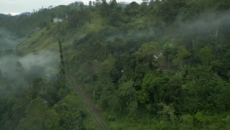 establishing aerial drone shot on foggy morning of ella hills with train track