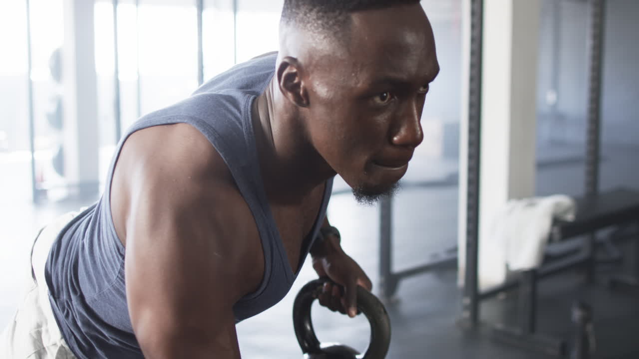 Exercising in gym, focused man lifting weights during intense workout session
