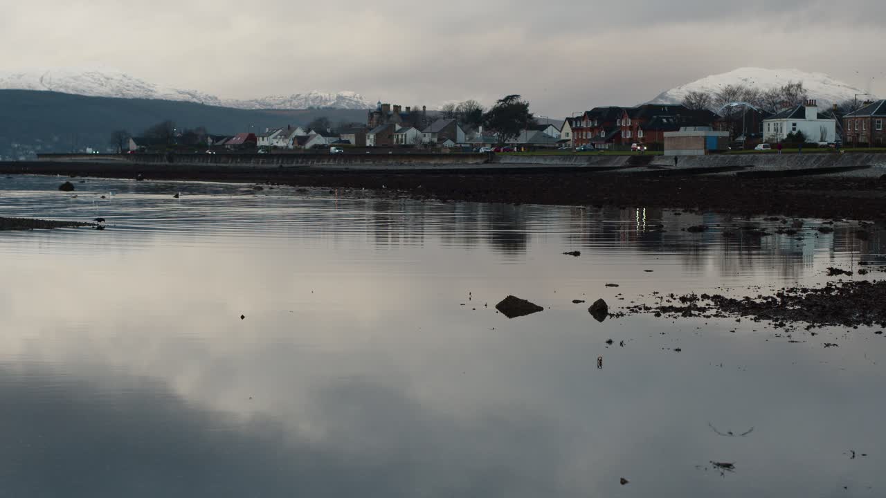 Tranquil Scottish Loch with Coastal Town and Snow-Capped Mountains