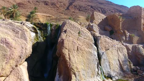 drone shot of a beautiful waterfall between desert mountains in bousaada algeria