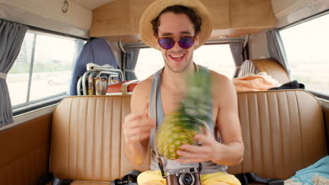 A-young-man-having-fun-playing-with-a-pineapple