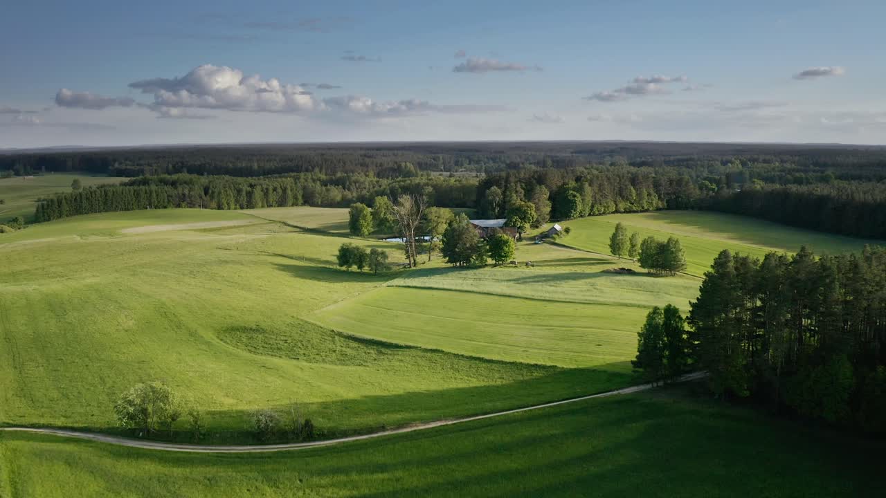 Idylleinen maisema vihreine peltoineen Warmian maaseudulla Puolassa – ilmakuva droonilla.