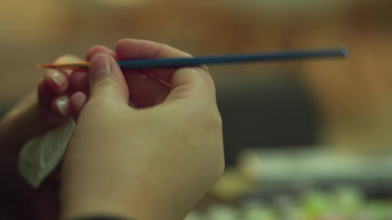 Paintbrush being cleaned in white tissue. Close up