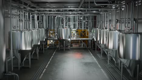 grandes tanques de fermentación de acero en una amplia sala de una moderna fábrica de producción de alcohol