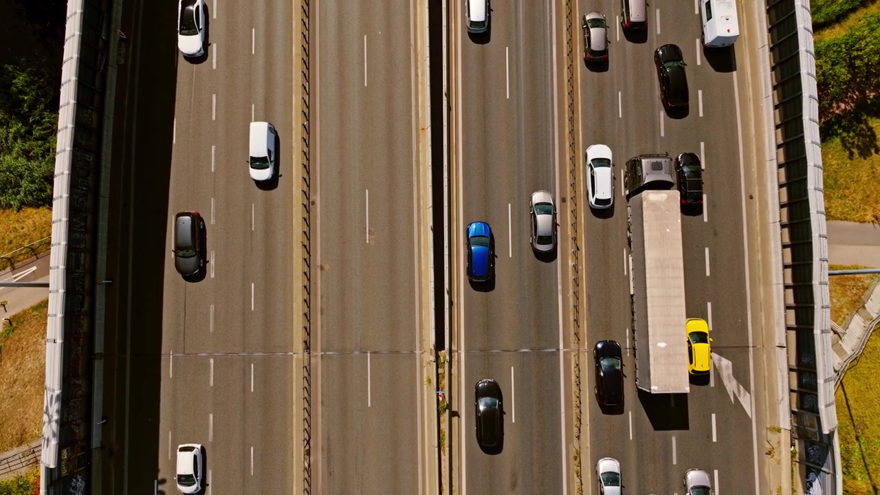 Il traffico sulla principale arteria stradale di Varsavia è diviso: un lato è congestionato, mentre l'altro scorre liberamente sotto il sole.
