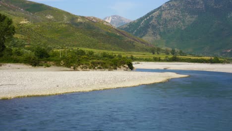 beautiful river landscape with valley and mountains background in lush vegetation, vjosa in albania