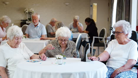 group of seniors playing game of bingo in retirement home