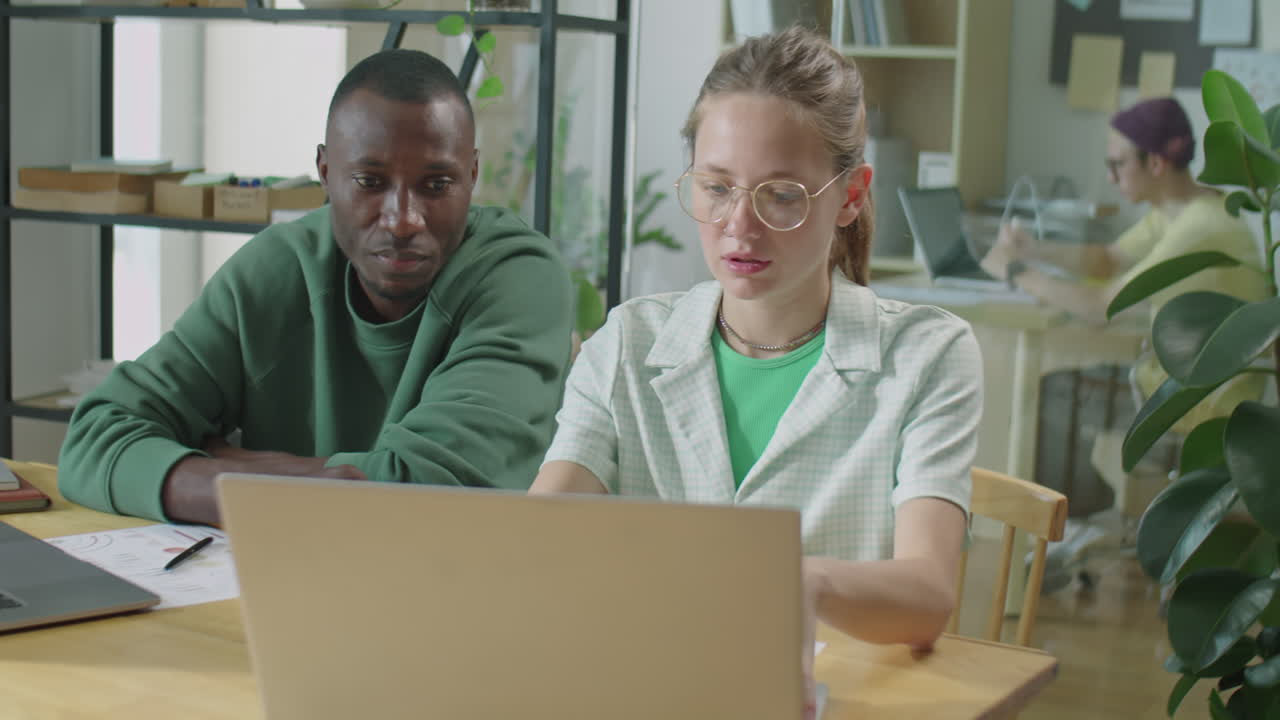 Multiethnic Male and Female Gen Z Colleagues Cooperating in Office