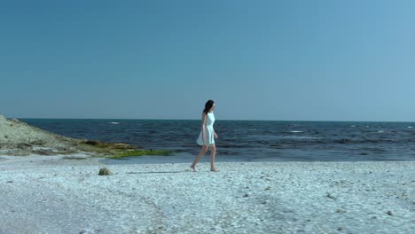 Linda-Chica-Con-Vestido-Blanco-Camina-Por-La-Playa