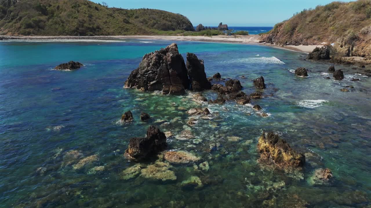 Proximity drone flight over visible underwater coral reef at low tide at La Morita beach, Tenacatita. Turquoise qazure crystal-clear calm waters. Mexico tourism hot spot in Jalisco