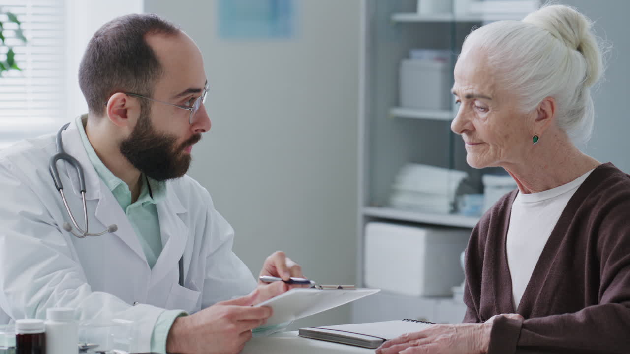 Doctor Consulting Elderly Woman during Medical Appointment in Clinic