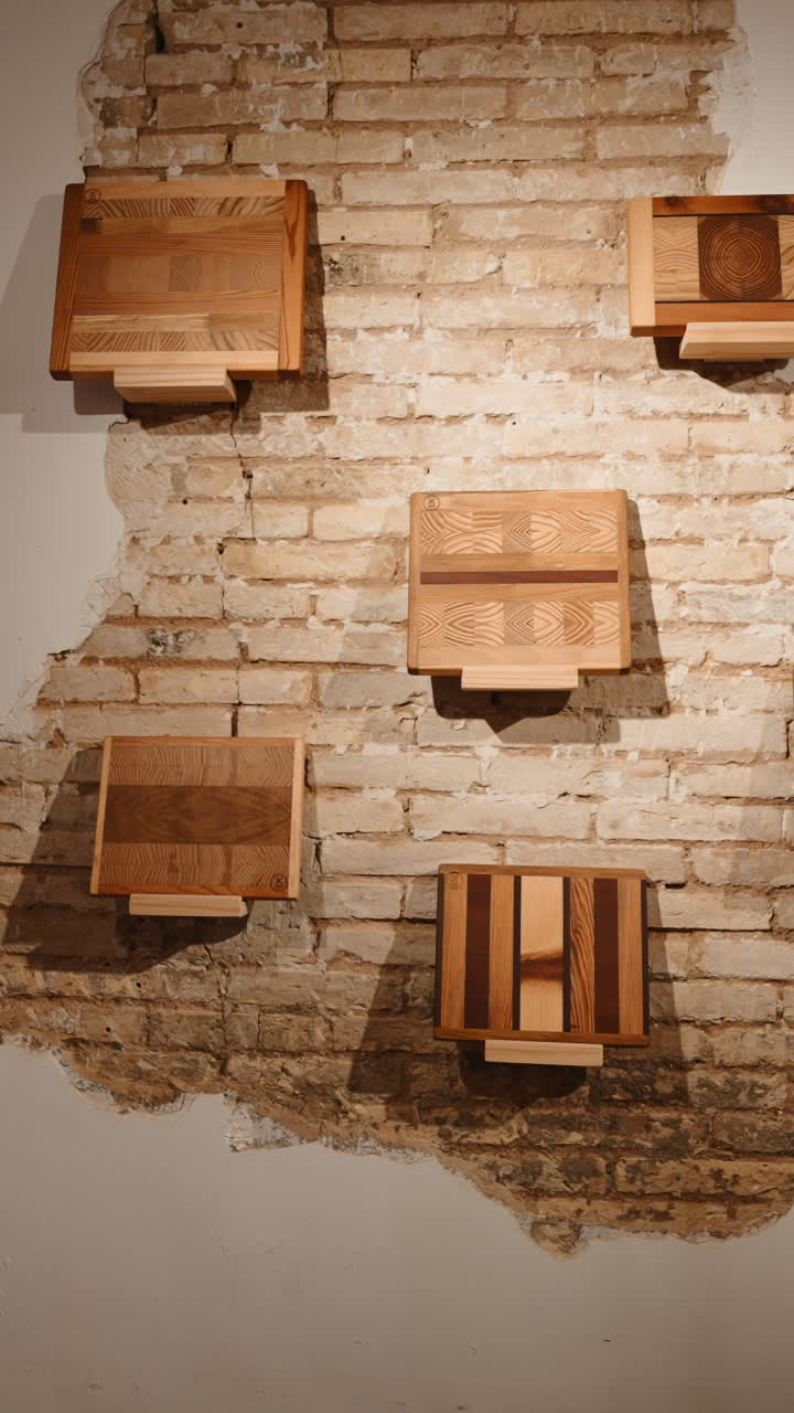 Taglieri in legno esposti su una parete di mattoni rustici