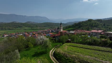 aerial: vipava cityscape during the day with church in slovenia, orbit drone shot
