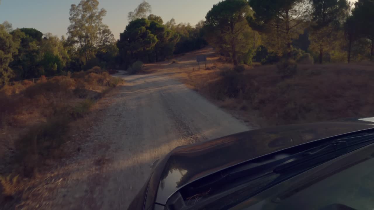 Vista frontale laterale di un'auto che percorre una strada di campagna