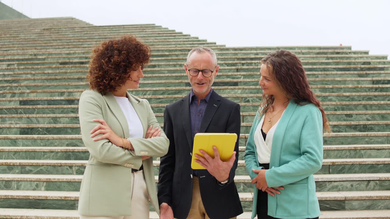 Business people collaborating on stairs with a tablet