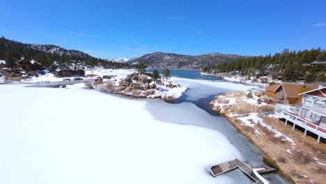 fpv drone flying through boulder bay in big bear lake after a winter snow storm