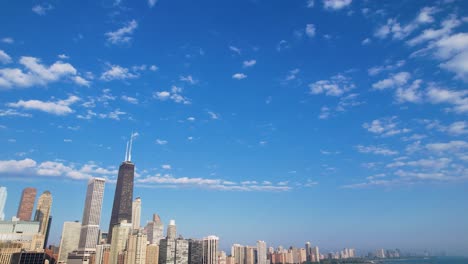 Tops-Of-City-Buildings-Under-Blue-Cloudy-Sky-Drone