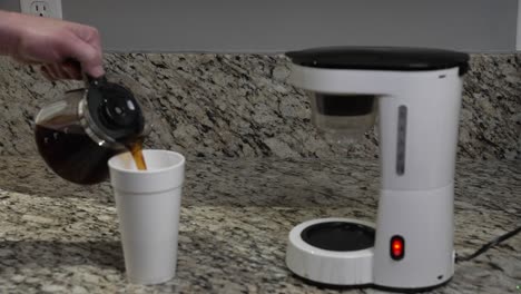 A-man-pours-fresh-hot-coffee-he-made-into-a-styrofoam-cup