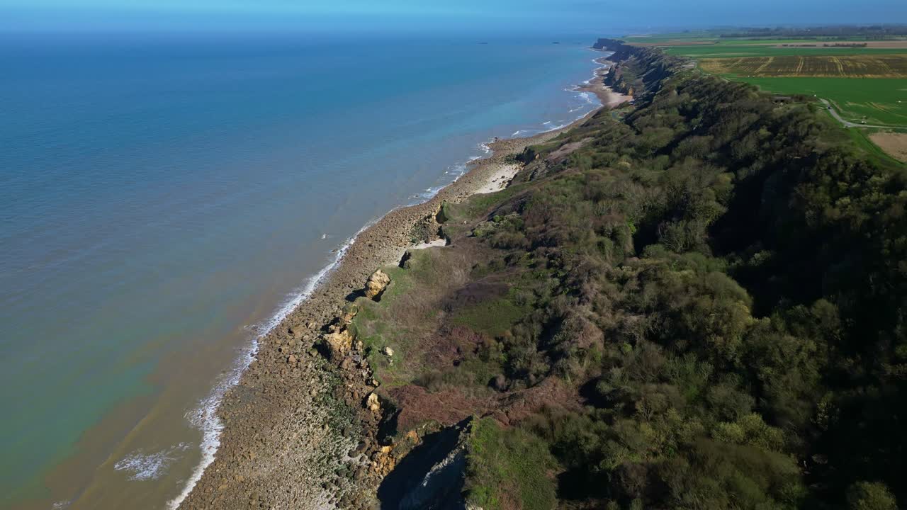 Scenic view of coastal cliffs and sea at Longues-sur-Mer, Normandy, France. Aerial forward