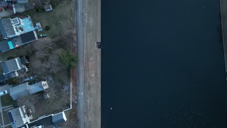 an aerial shot directly above a pond in a suburban neighborhood on long island, ny