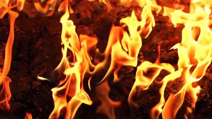 Video ravvicinato di fiamme vivaci, che cattura il movimento dinamico da una bassa angolazione.