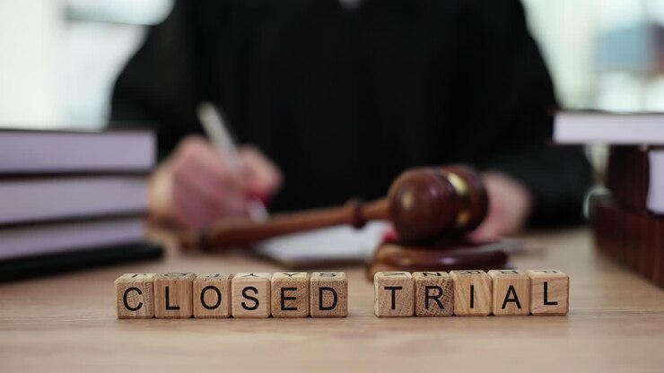 Blocchi di legno di un processo a porte chiuse con giudice e martelletto sullo sfondo