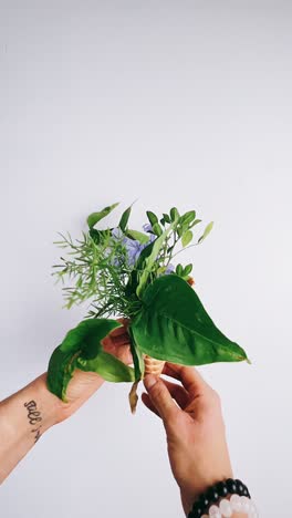 hands holding a bouquet of flowers and plants
