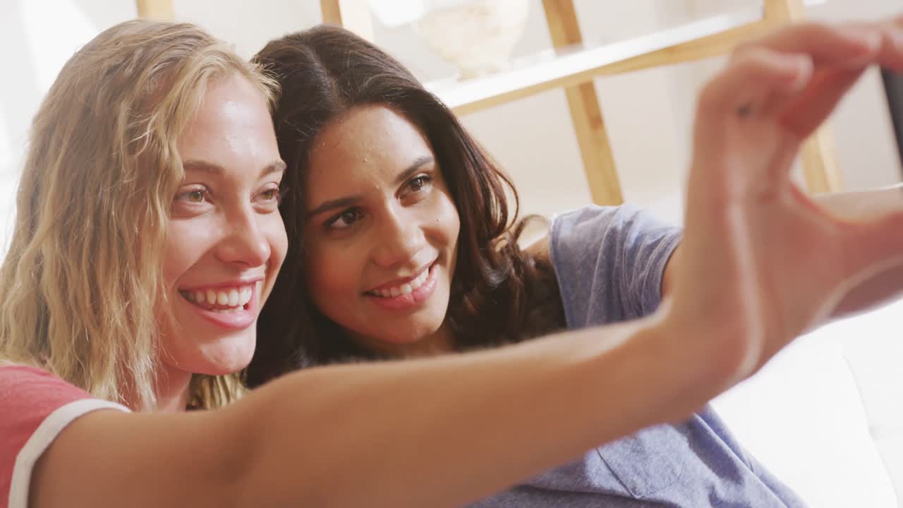 Due giovani amiche che si scattano un selfie al chiuso