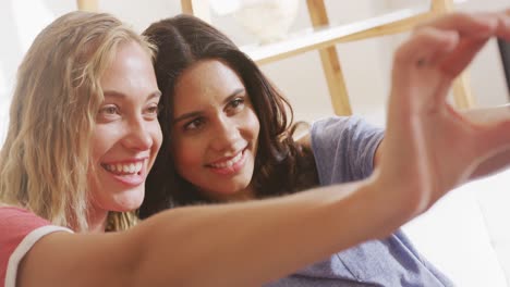 dos amigas jóvenes tomando un selfie en el interior