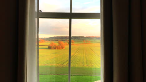 Blick-Durch-Vorhänge-Auf-Ein-Goldenes-Feld-Von-Einem-Herrenhaus-In-Leicestershire