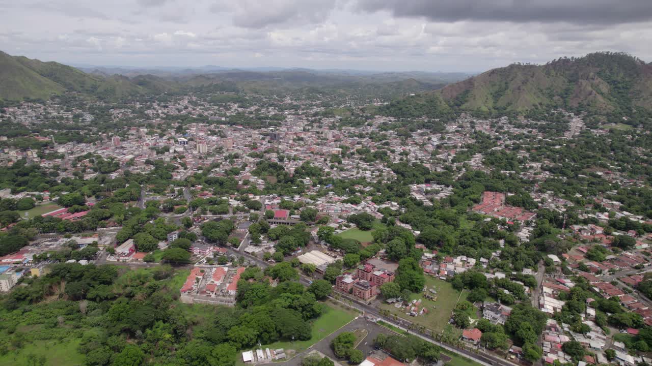 Zoom aereo che si allontana dalla città di San Juan de Los Morros con montagne e alberi verdeggianti, Venezuela