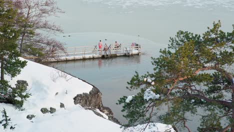 Grupo-De-Nadadores-De-Hielo-Entrando-Al-Agua-En-Una-Fría-Noche-De-Invierno