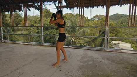 woman practicing martial arts in an abandoned tropical building