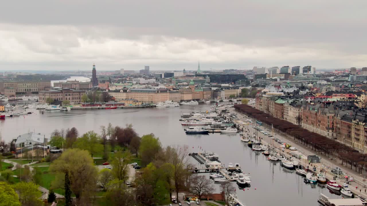 Wide aerial rising shot over Stockholm, gradually revealing the city’s skyline under soft spring light