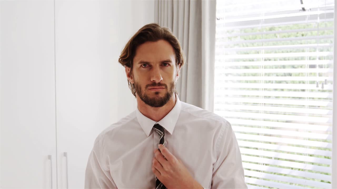 침실에서  ⁇ 타이를 조정하는 남자