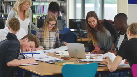 Maestra-Trabajando-Con-Estudiantes-Universitarios-En-La-Biblioteca