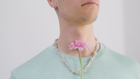 Nahaufnahme-Junger-Mann-Mit-Halskette-Und-T-Shirt,-Der-Eine-Blume-Hält-1