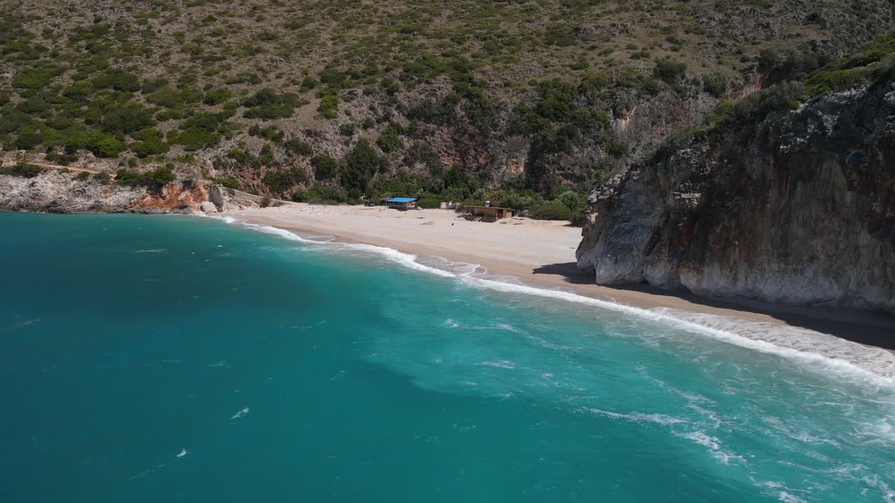 Waves washing on sand, secluded Gjipe Beach surrounds by mountains , Albania