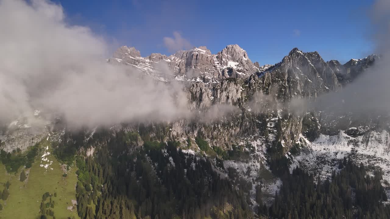 Fog clearing revealing Swiss Switzerland mountains, nature highlands aerial