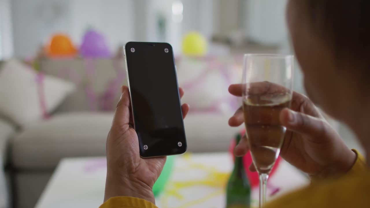 African american senior making new year's eve smartphone video call, copy space on screen